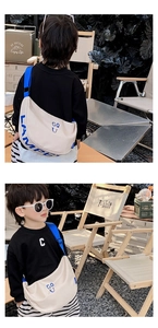 Detail of child wearing a beige canvas crescent bag with a blue adjustable strap