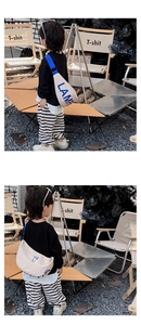 Detailed view of kids canvas chest bag with blue strap and letter print detail