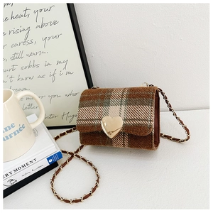 Detail of vintage plaid mini crossbody bag with a gold heart lock and woven chain strap
