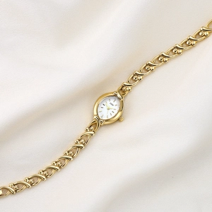 Elegant gold GEDI women's watch with an oval white dial and decorative X-link bracelet