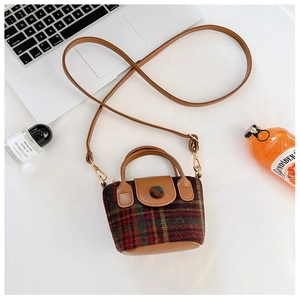 Detailed overhead view of a mini plaid crossbody bag with brown leather trim and gold buckle