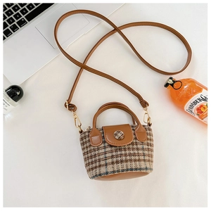 Mini brown plaid crossbody bag shown next to lifestyle items on white background