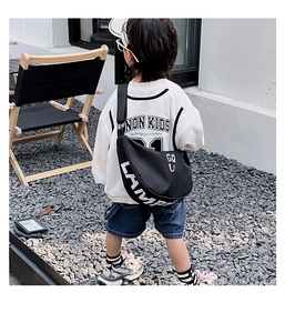 Detailed view of the black canvas crescent bag with white letter print for kids