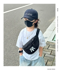 Detail of child wearing a black canvas chest bag with NY logo in a streetwear outfit