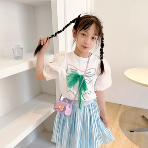Girl's mini PU crossbody bag with bow detail paired with white tee and blue pleated skirt