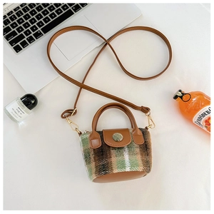 Macro view of vintage plaid mini crossbody bag with green wool fabric and brown leather trim