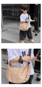 Detail of children's beige canvas crossbody bag with letter print and black strap