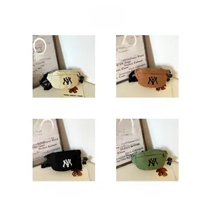 Detail display of canvas belt bags for kids with NY logo and bear keychain in four colors