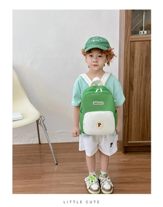 Close-up of green and white color-block kids backpack featuring a round 'P' logo