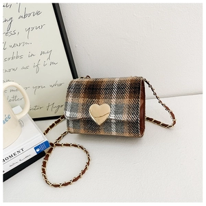 Detail of vintage plaid girl's crossbody bag with large gold heart metal buckle clasp