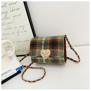 Close-up of retro plaid tweed crossbody bag with golden heart-shaped metal buckle