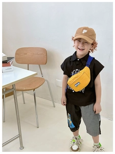 Detailed view of yellow canvas kids chest bag with blue adjustable strap and brown cap