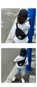 Detail of a black canvas waist bag for kids featuring a white NY logo on a street model