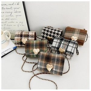 Detail of mini tweed crossbody bags with heart-shaped gold buckles and chain straps