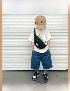 Detail of black canvas kids chest bag with PEACE patch on a white street background