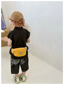 Detail of yellow nylon waist bag for kids shown in a coordinated outdoor fashion outfit