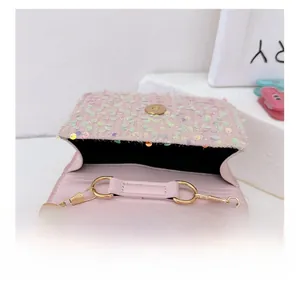 Close-up of pink sequin crossbody bag showing magnetic buckle and gold chain strap
