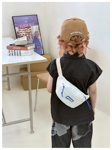 Detail view of white canvas kids waist bag featuring blue zipper cord and colorful logo