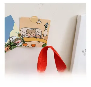 Detail of red woven handle and thick stitching on a beige canvas toddler backpack