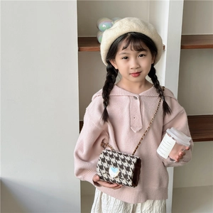 Pink knit girl's sweater with a mini houndstooth crossbody bag and heart buckle