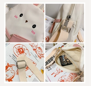Detail of cute rabbit embroidery on canvas crossbody bag with metal zipper and strap buckle