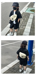 Detail view showing a cream canvas kids fanny pack with NY logo in a street fashion outfit