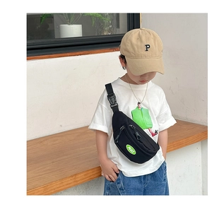 Detail view of black canvas kids chest bag with green PEACE logo and adjustable strap