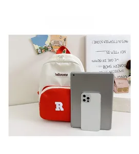 Contrast color canvas kids backpack shown with tablet and phone for size reference