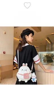 Cute white bunny canvas shoulder bag with pink pocket and plush charm shown on model
