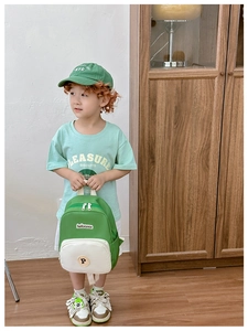 Kid carrying a lightweight color-block canvas backpack for school featuring a P-badge detail