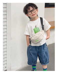 Kid's canvas chest bag in cream with green PEACE patch shown on a child model