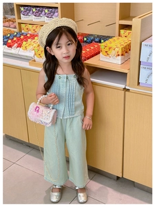 Detail of light green girls' summer set featuring pleated sleeveless top and wide-leg pants