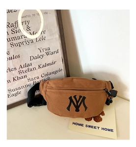 Close-up of brown canvas waist bag with NY embroidery and a cute teddy bear charm