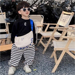 Minimalist canvas smile backpack with blue strap shown on a kid in outdoor camping