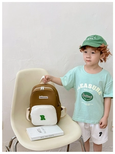 Detail of color-block canvas kids backpack with green embroidered letter R and brown base