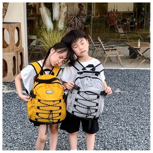 Detailed view of yellow and grey canvas backpacks with elastic cords and zippers