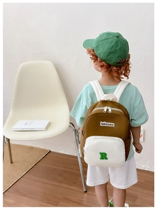 Detail view of the lightweight color-block canvas backpack with adjustable straps on a child