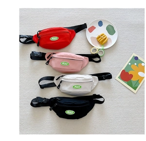 Flat lay of four colorful canvas waist bags for kids with PEACE patch and adjustable straps
