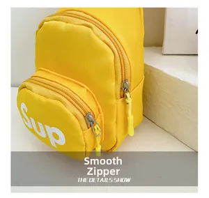 Close-up of smooth yellow nylon zippers and Sup logo on kid shoulder bag
