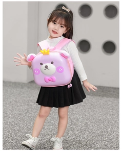 Detail view of pink 3D cartoon bear hardshell backpack on a young girl outdoors
