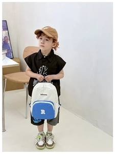Close-up of contrast color canvas kids backpack with blue pocket and letter R detail