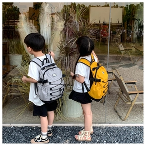 Detail of adjustable padded shoulder straps and side mesh pockets on kids canvas backpack