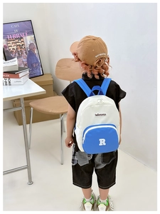 Detailed close-up of a blue and white canvas kids backpack and brown baseball cap