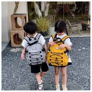 Close-up of durable canvas kids backpacks in yellow and gray with drawstring detail