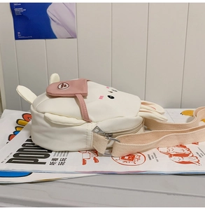 Detail of white canvas rabbit crossbody bag showing 3D ears and small side pocket