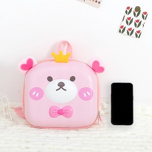Pink cartoon bear hardshell toddler backpack shown with phone for size reference