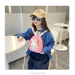 Pink canvas kids backpack with a 3D plush rabbit doll worn by a stylish young girl
