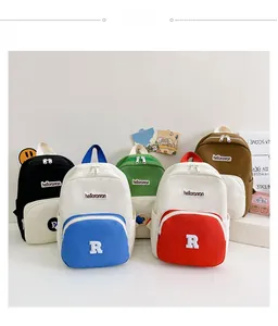 Detail of colorful canvas backpacks for kids with vibrant letter embroidery patches
