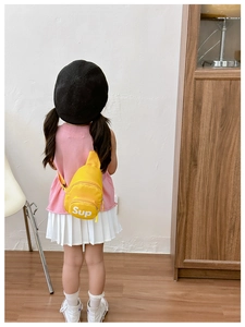 Kids bright yellow canvas chest bag with Sup logo shown on a child in a home setting