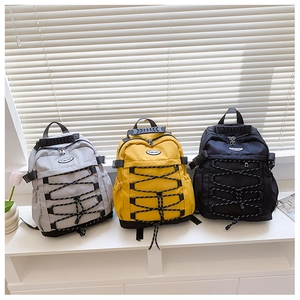 Close-up of lightweight kids canvas backpacks with drawstring cords in grey, yellow, and black